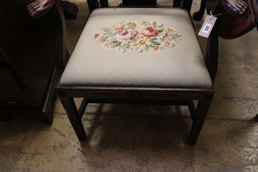 A pair of 19th century mahogany elbow chairs, scroll and leaf-carved and with lions paw armrests